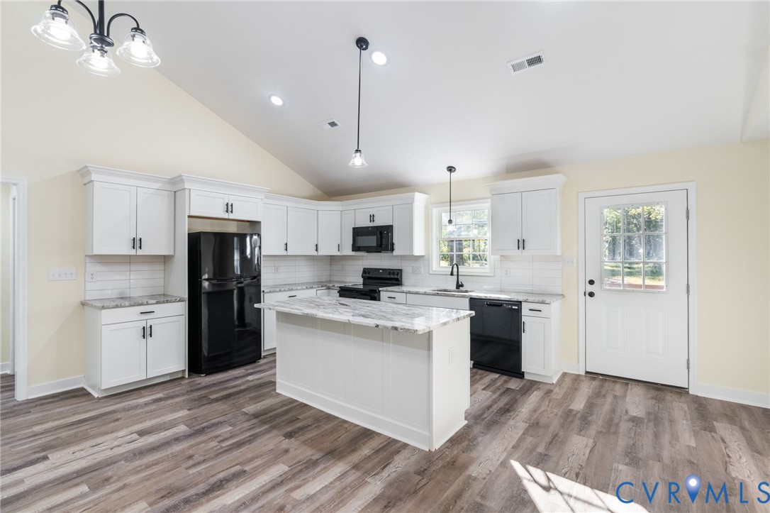 11206 South Crater Road Petersburg, VA 23805 - Photo 9 of 19 a kitchen with stainless steel appliances kitchen island granite countertop a refrigerator a sink dishwasher a stove and white cabinets with wooden floor