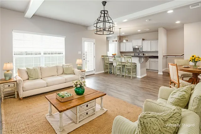a living room with furniture kitchen view and a large window