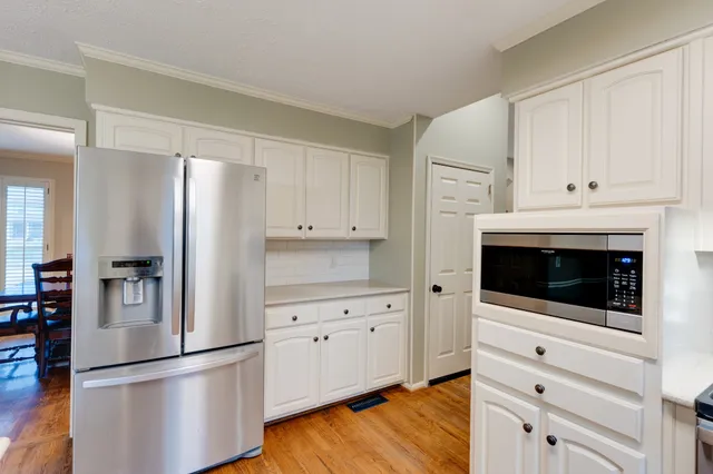 a kitchen with white cabinets and stainless steel appliances