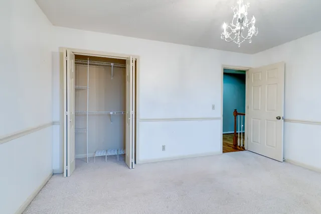 a view of an empty room with chandelier