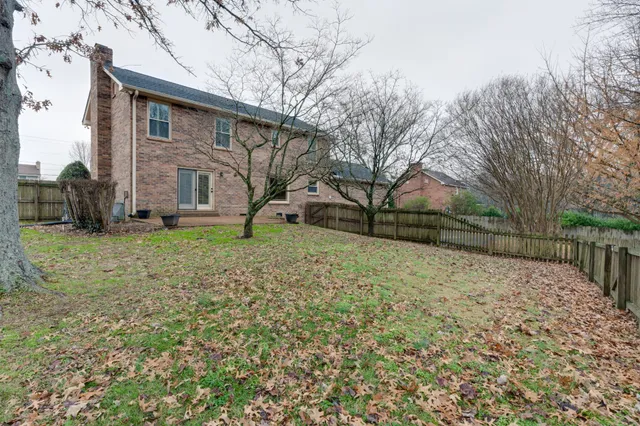 a view of a yard covered with snow in front of house