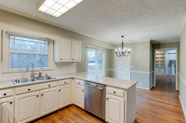 a kitchen with a sink cabinets and wooden floor