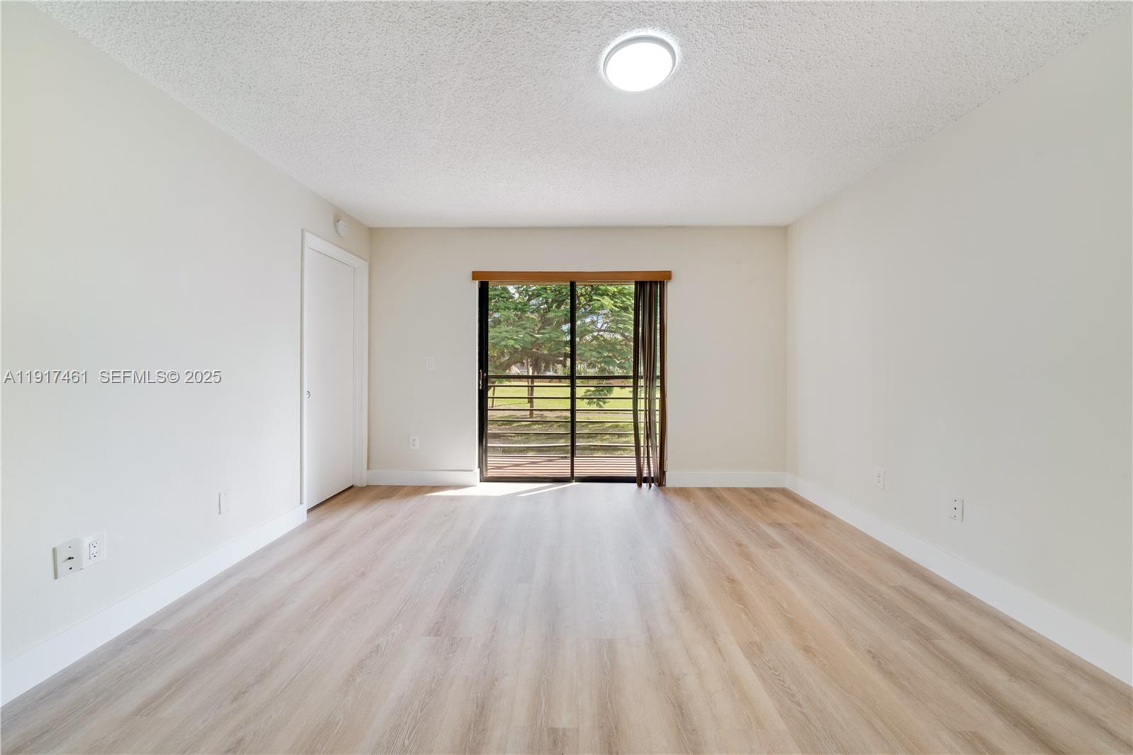 14847 Southwest 104th Street, Unit 10203 Miami, FL 33196 - Photo 14 of 22 an empty room with wooden floor and windows