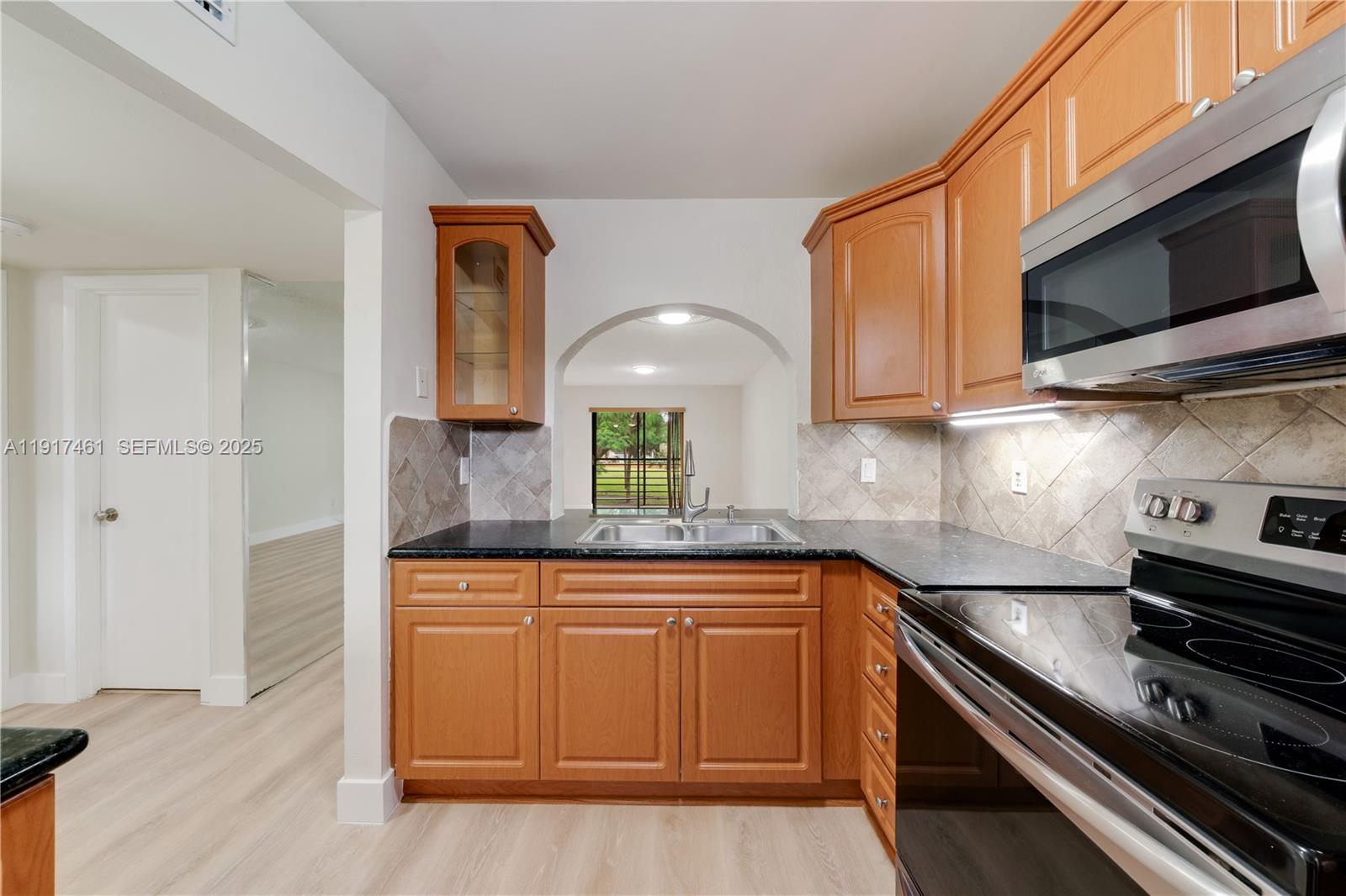 14847 Southwest 104th Street, Unit 10203 Miami, FL 33196 - Photo 4 of 22 a kitchen with stainless steel appliances granite countertop a sink and a stove