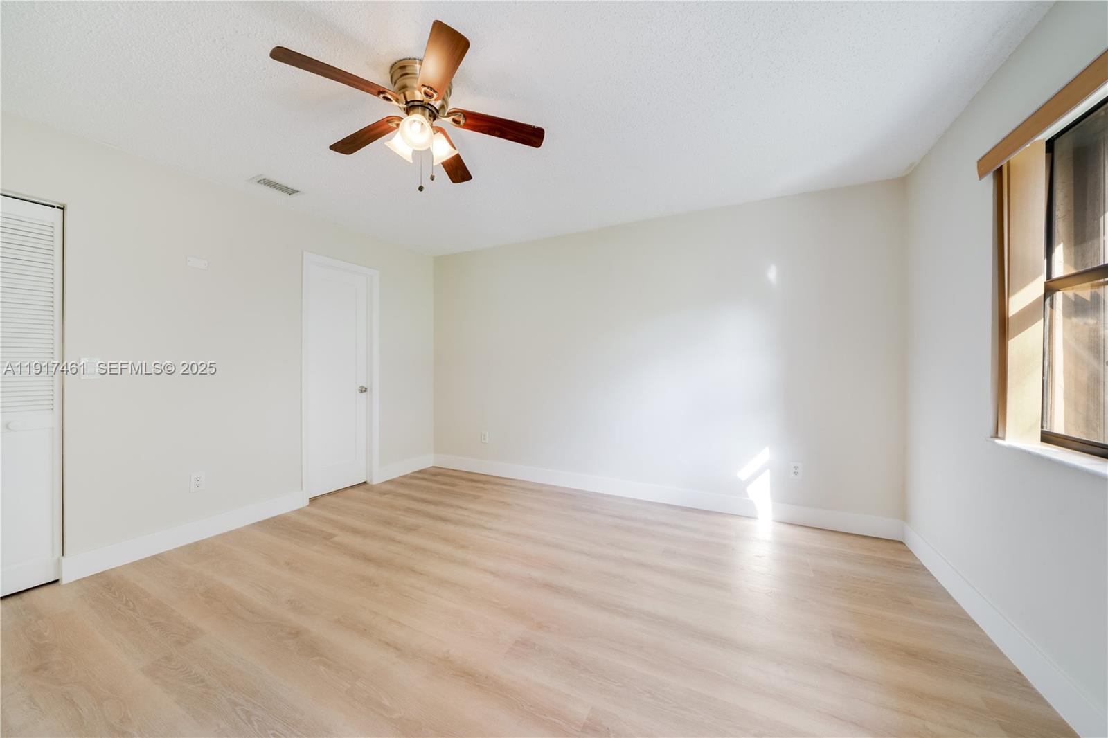 14847 Southwest 104th Street, Unit 10203 Miami, FL 33196 - Photo 8 of 22 wooden floor in an empty room with a window