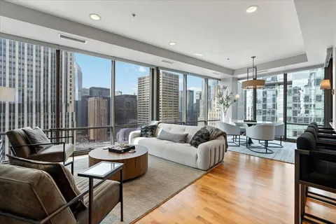 a living room with furniture and floor to ceiling windows