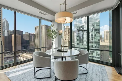 a dining room with furniture a chandelier and wooden floor