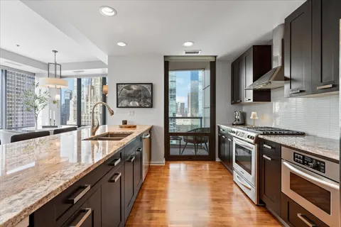 a large kitchen with stainless steel appliances granite countertop a stove and a sink