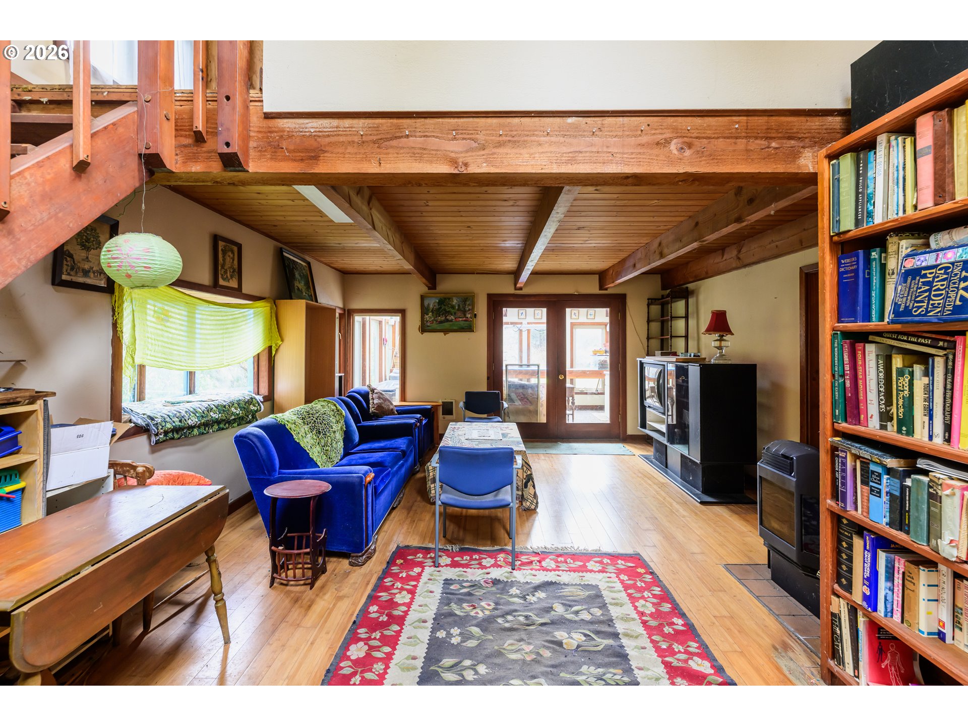 1377 Moonshine Park Road Logsden, OR 97357 - Photo 11 of 40 a living room with furniture a rug and a book shelf
