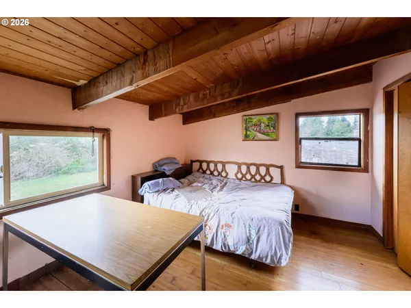 a bed sitting in a bedroom next to a window