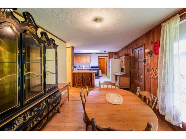 a living room with furniture a flat screen tv and a refrigerator