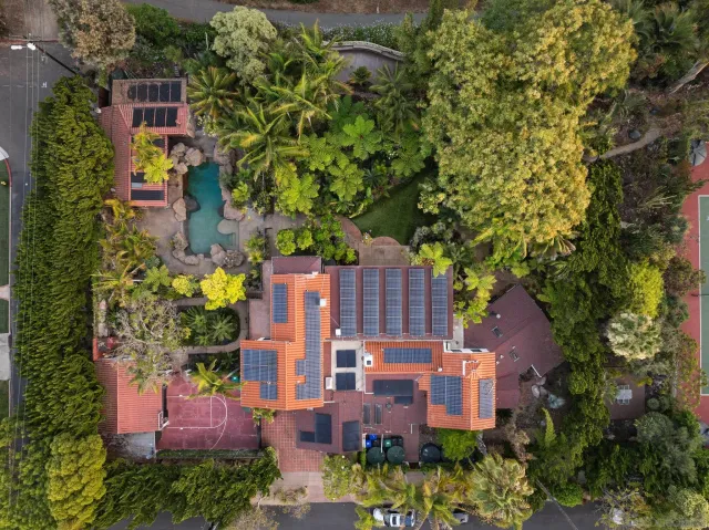 an aerial view of a house with a yard and large trees