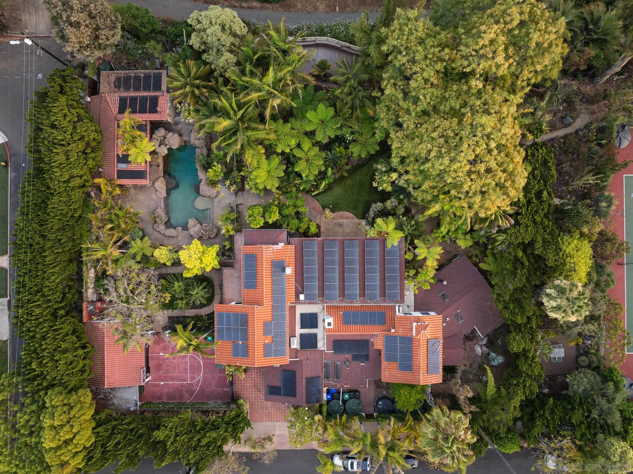 an aerial view of a house with a yard and large trees