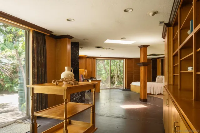 a spacious bedroom with a large bed and a chandelier