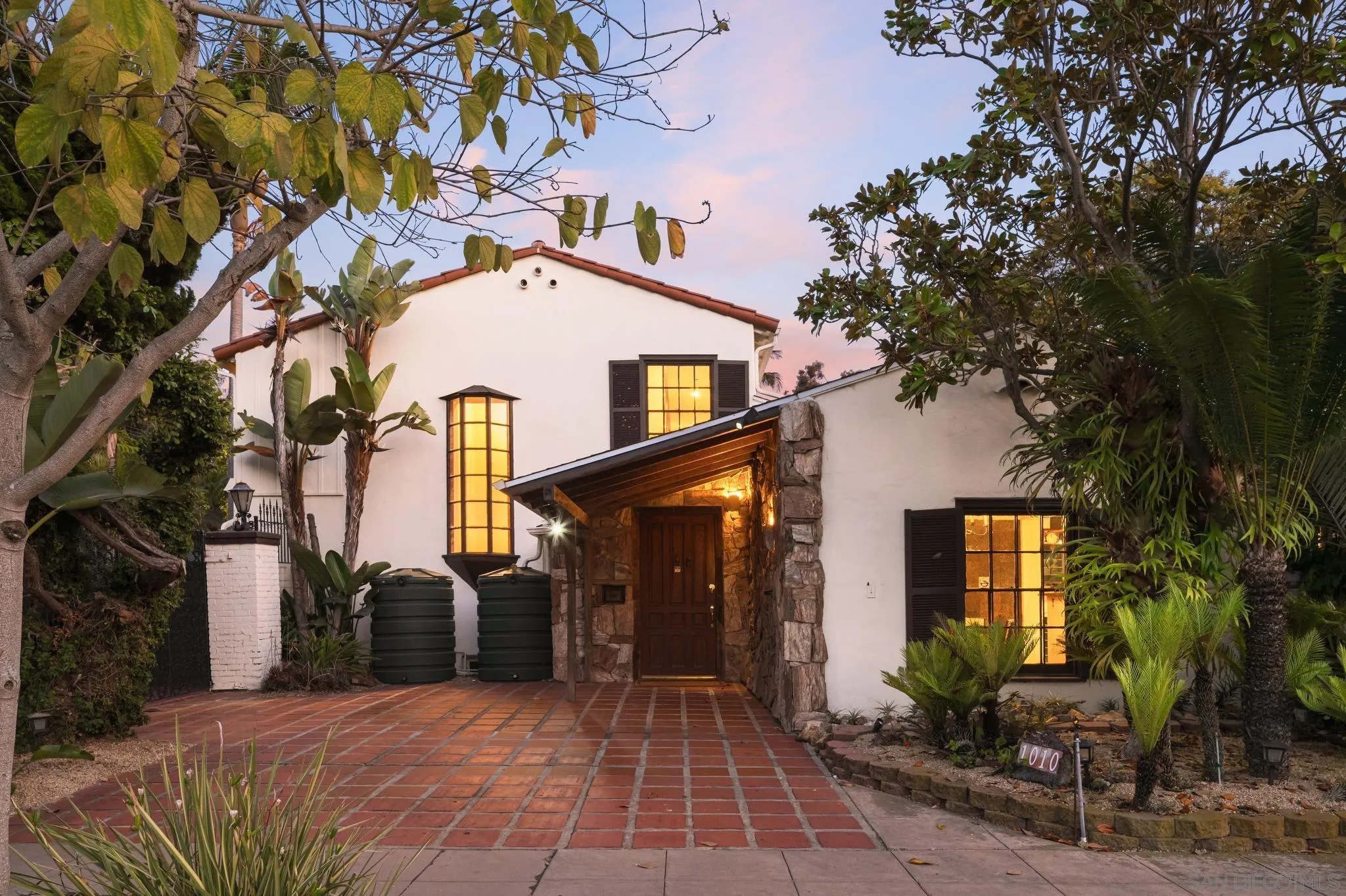 1010 Myrtle Way San Diego, CA 92103 - Photo 4 of 70 a view of a brick house with large windows and a large tree