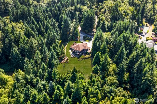 a backyard of a house with outdoor seating and covered with trees