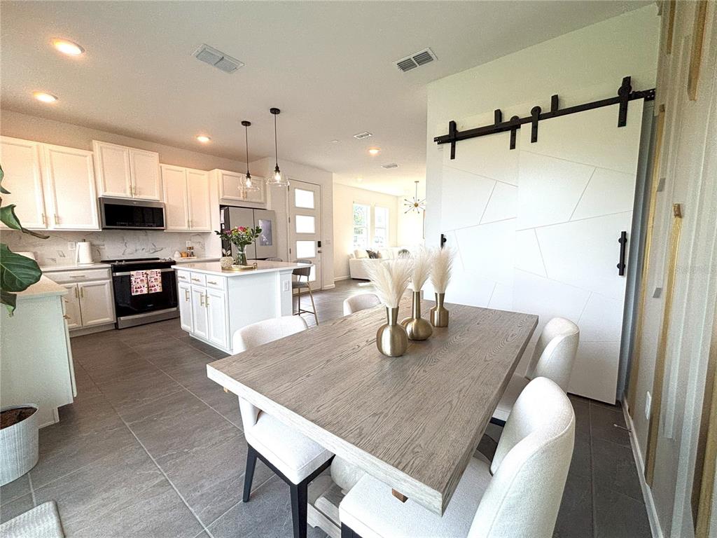 921 Spring Palms Loop Orlando, FL 32828 - Photo 2 of 30 a dining room with kitchen island a table and chairs