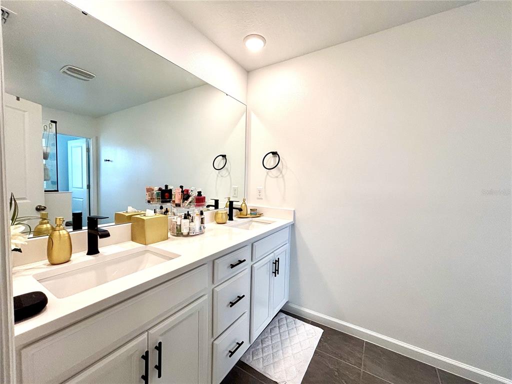 921 Spring Palms Loop Orlando, FL 32828 - Photo 3 of 30 a bathroom with a sink and a mirror