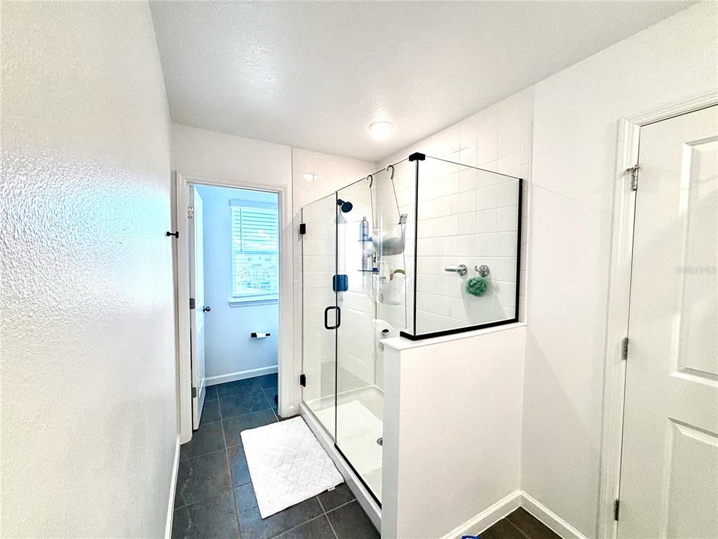 921 Spring Palms Loop Orlando, FL 32828 - Photo 4 of 30 a bathroom with a shower and a mirror