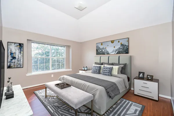 a bedroom with a bed and wooden floor