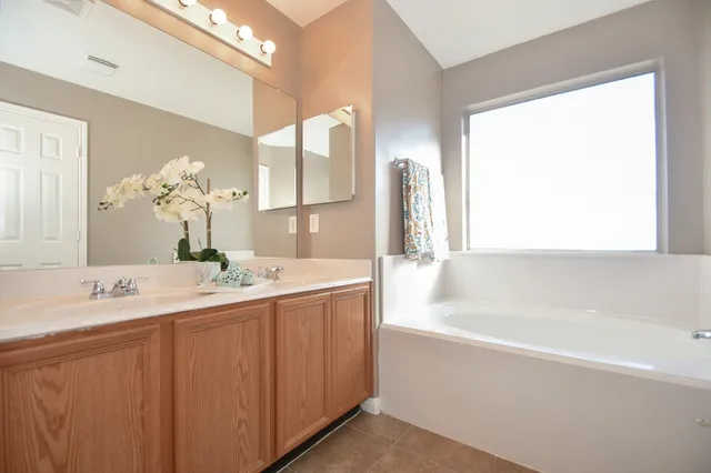 a bathroom with a tub sink and mirror