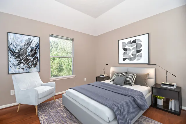 a bedroom with bed and a painting on the wall