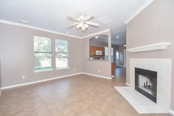 an empty room with windows and fireplace
