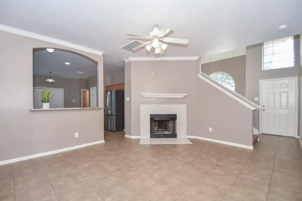a view of a livingroom with a ceiling fan fireplace and a window