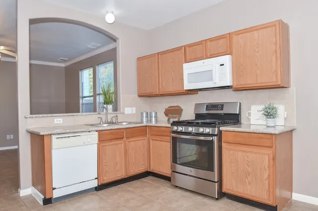 a kitchen with stainless steel appliances granite countertop a stove and white cabinets