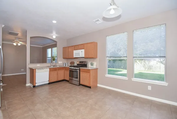 a large kitchen with kitchen island a large counter space a sink stainless steel appliances and cabinets