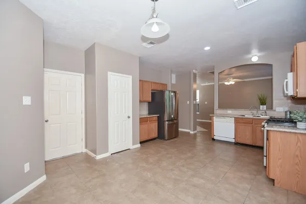 a large white kitchen with a large window and stainless steel appliances