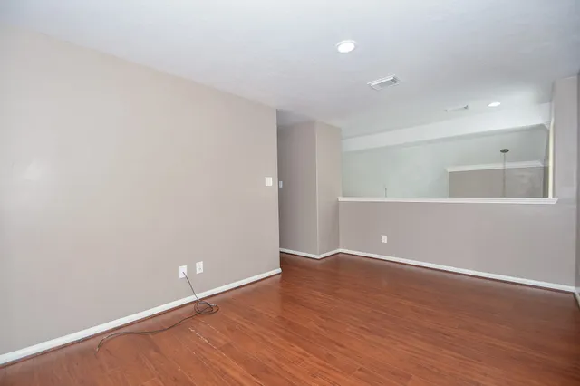 a view of an empty room with wooden floor
