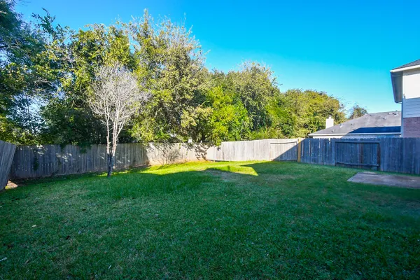 a view of yard with swimming pool and wooden fence