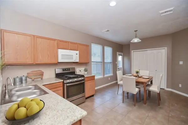 a kitchen with a dining table chairs and stove