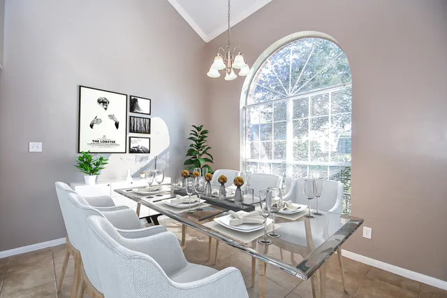 a dining room with furniture a large window and a chandelier