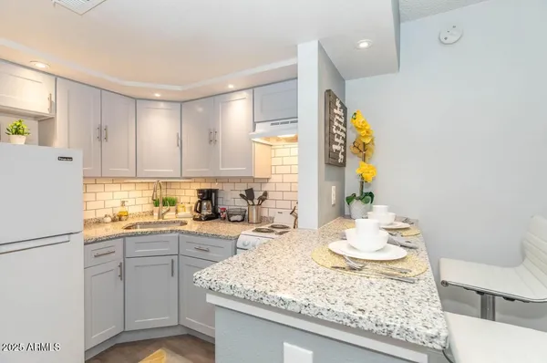 a kitchen with a sink a stove cabinets and counter space