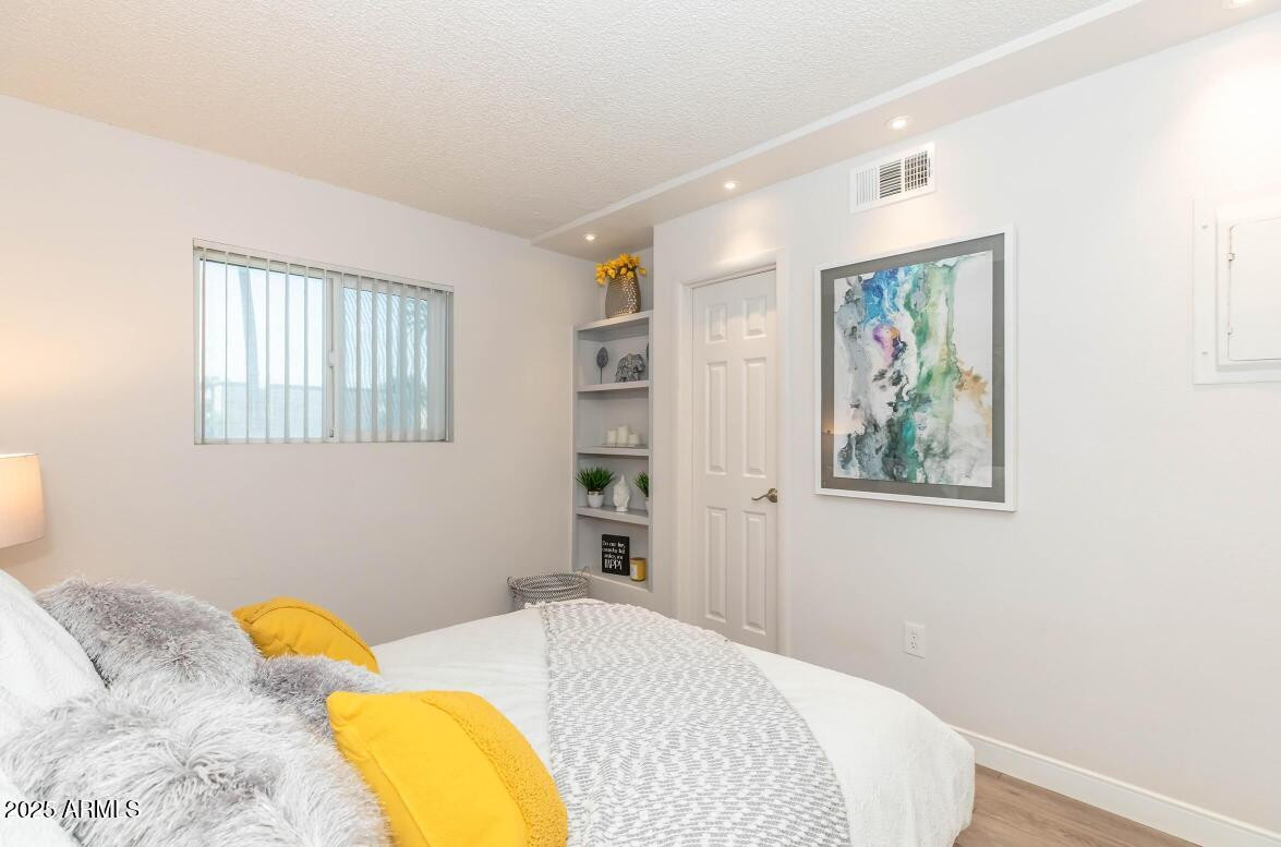 2936 East Indian School Road, Unit 1 Phoenix, AZ 85016 - Photo 5 of 12 a bedroom with a bed and a painting on the wall