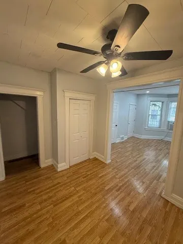 a view of an empty room with window and wooden floor