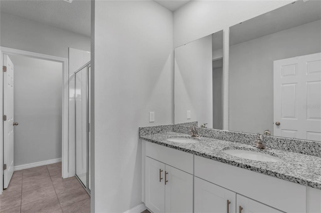 3472 Monaco Drive Davenport, FL 33897 - Photo 13 of 25 a bathroom with a granite countertop sink and a mirror