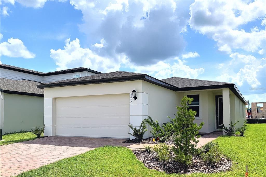 3472 Monaco Drive Davenport, FL 33897 - Photo 2 of 25 a front view of a house with a yard and garage