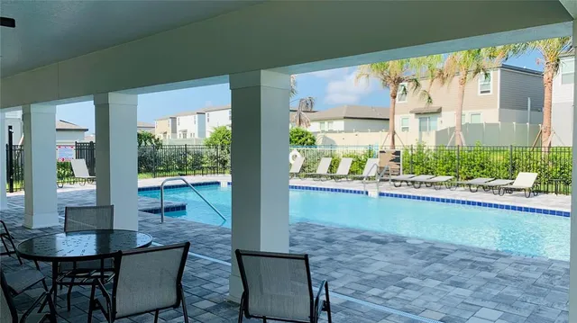 a view of swimming pool with outdoor seating and a patio