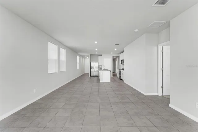 a kitchen with stainless steel appliances granite countertop a refrigerator a stove a sink and white cabinets