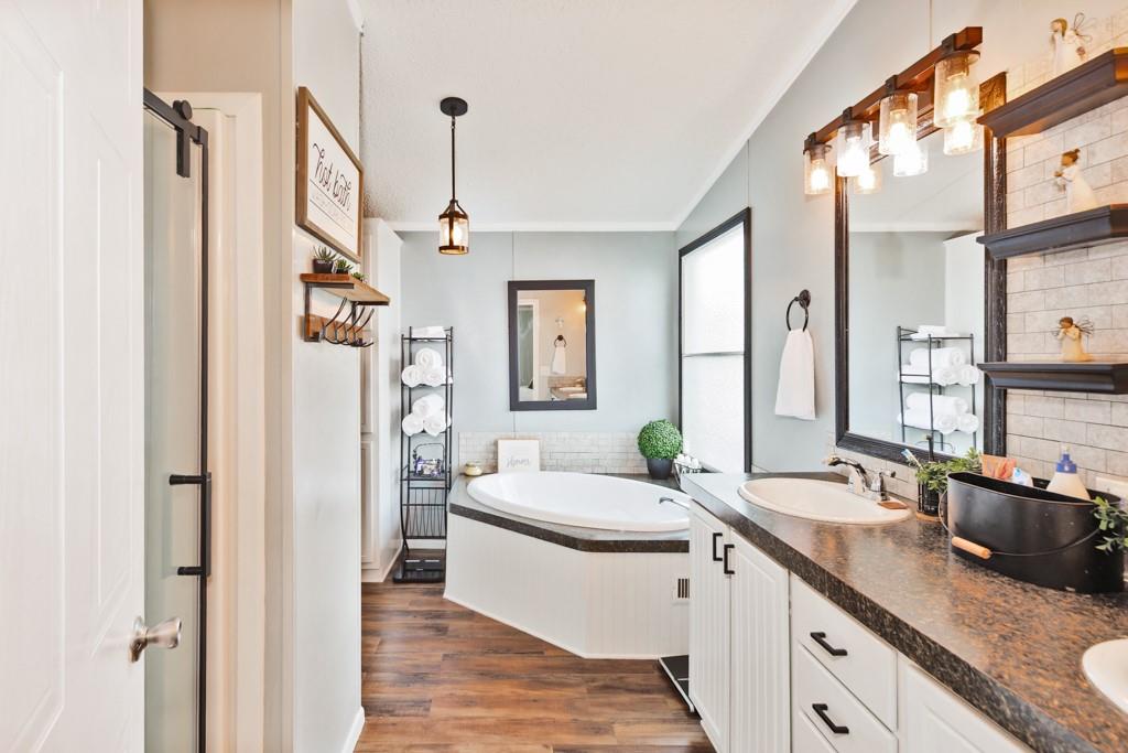 297 Lone Tree Lane Decatur, TX 76234 - Photo 11 of 20 Bathroom featuring double vanity, dark wood-type flooring, a garden tub, and ornamental molding