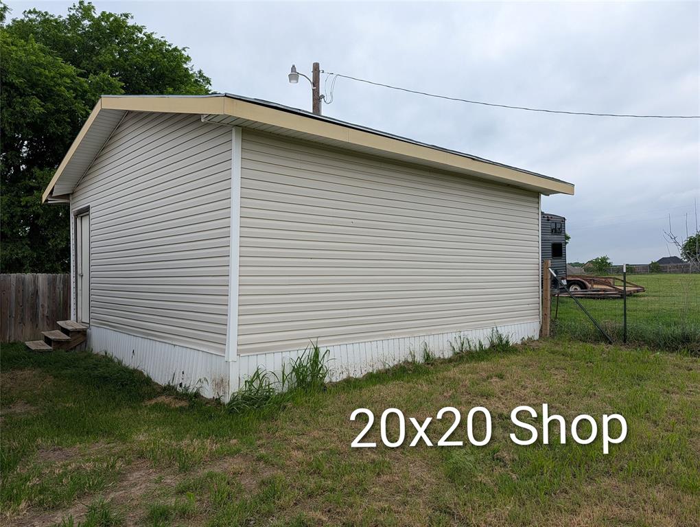 297 Lone Tree Lane Decatur, TX 76234 - Photo 18 of 26 The property includes a detached shop with light-colored siding and a contrasting roof trim