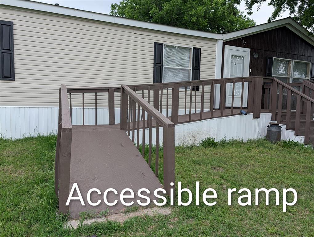 297 Lone Tree Lane Decatur, TX 76234 - Photo 22 of 26 The property features an accessible ramp leading to the entrance, a front door, and exterior siding
