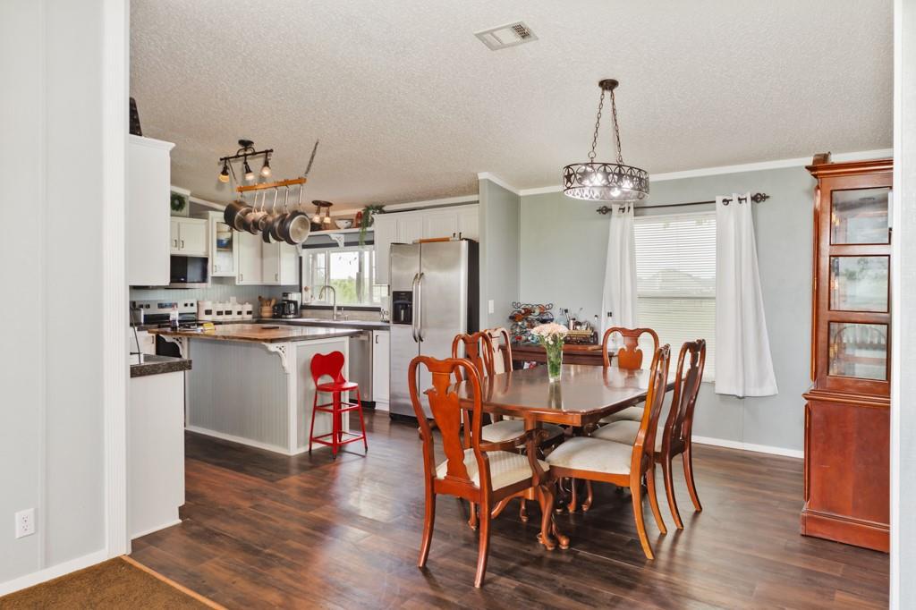 297 Lone Tree Lane Decatur, TX 76234 - Photo 7 of 20 Dining room with ornamental molding, dark wood-style flooring, and a textured ceiling