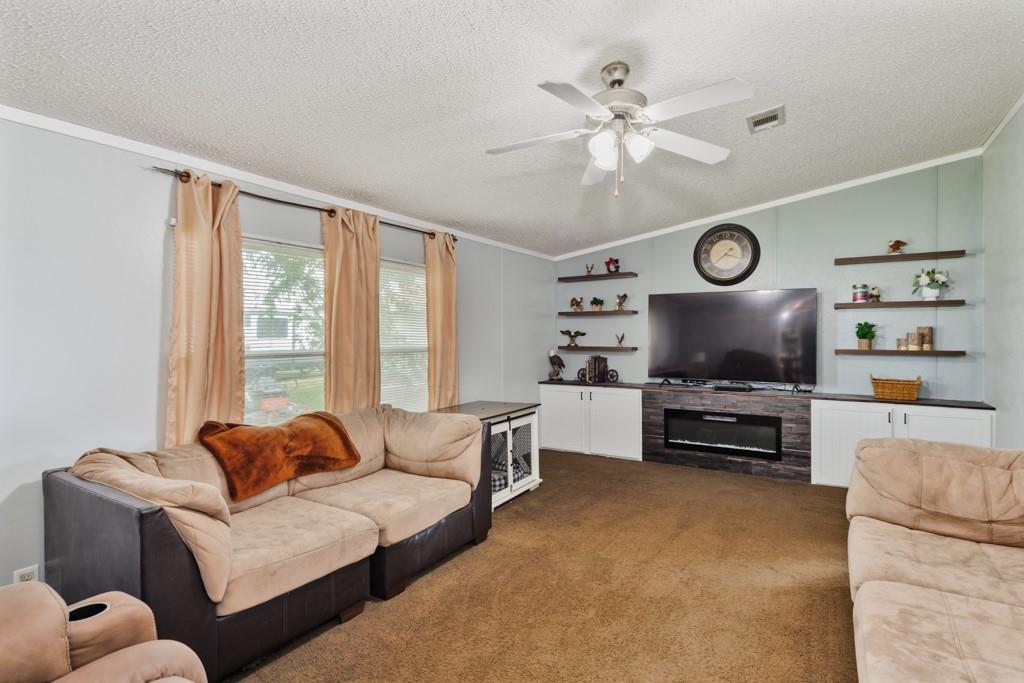 297 Lone Tree Lane Decatur, TX 76234 - Photo 8 of 20 Living room with electric fireplace, ornamental molding, ceiling fan