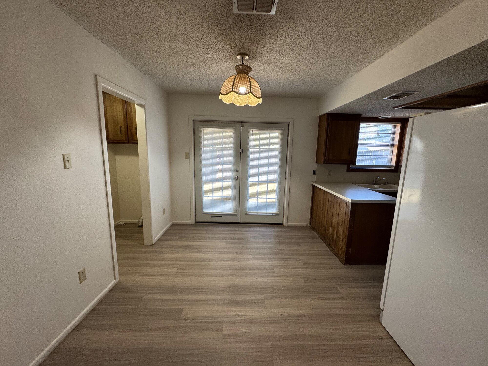 7403 Utica Avenue, Unit B Lubbock, TX 79424 - Photo 3 of 9 wooden floor in an empty room with a window