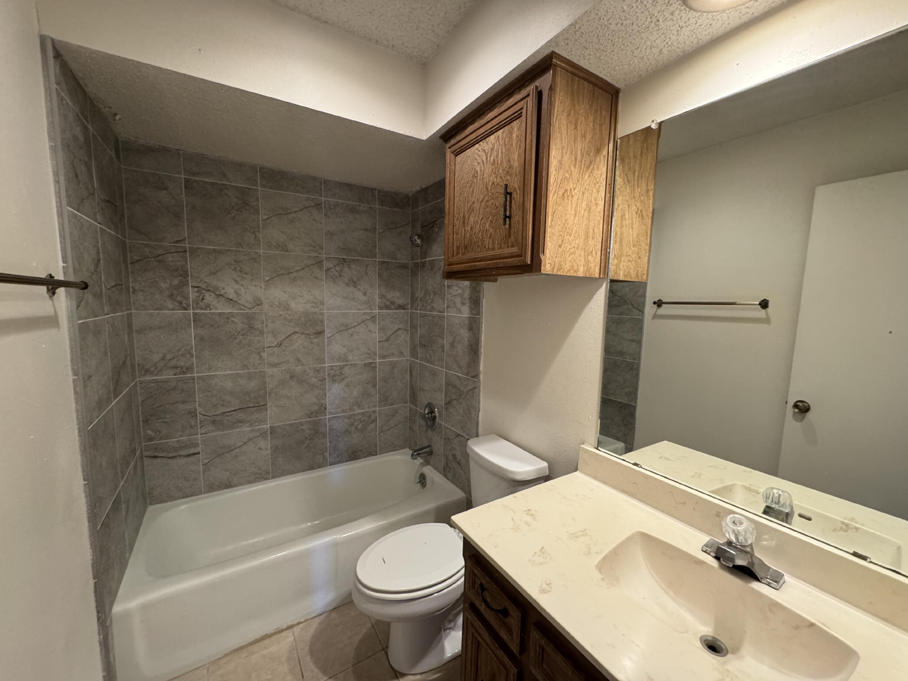 7403 Utica Avenue, Unit B Lubbock, TX 79424 - Photo 6 of 9 a bathroom with a sink a toilet and shower