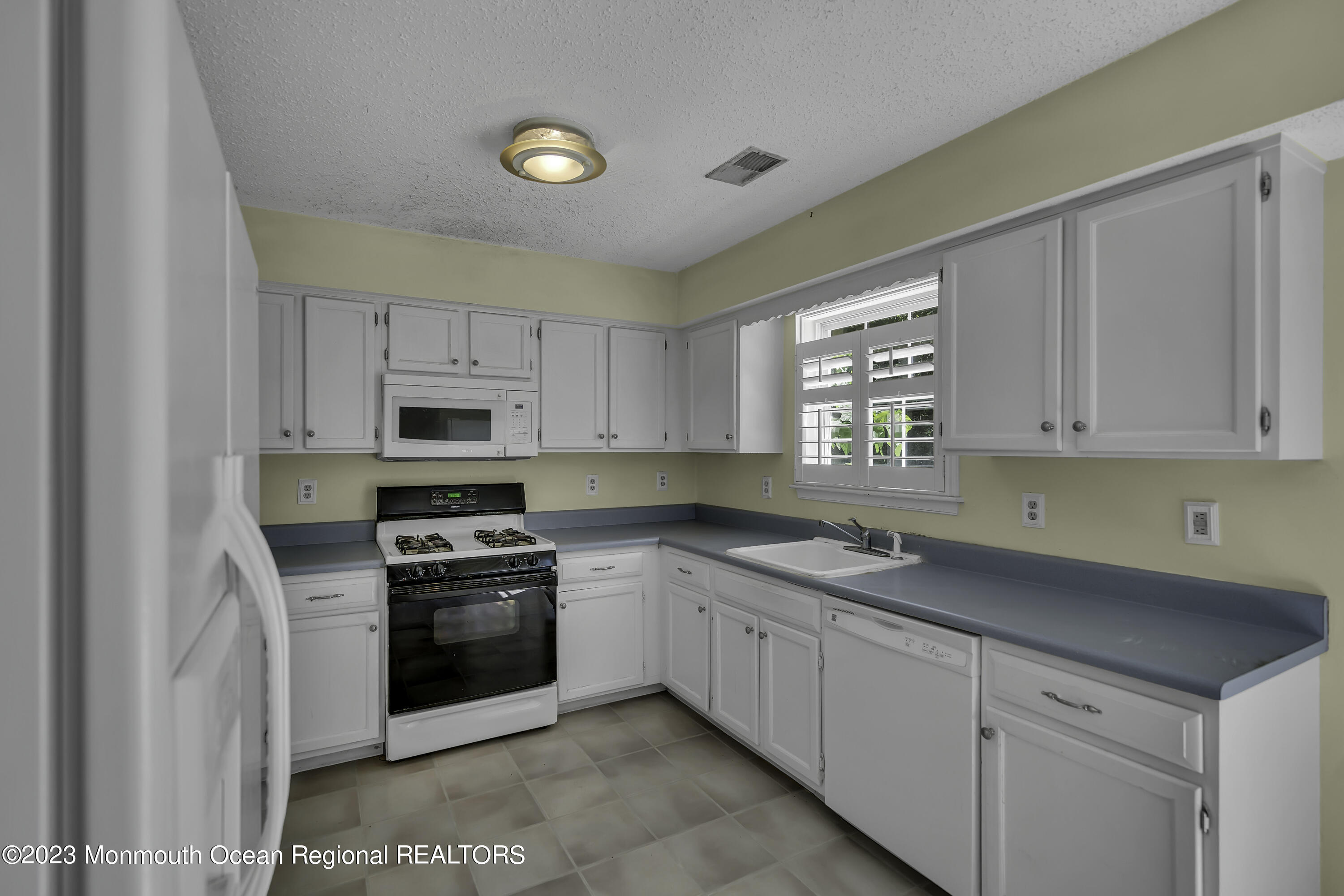 244 Down Hill Run Toms River, NJ 08755 - Photo 18 of 44 a kitchen with white cabinets appliances and a window